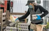  ?? AP ?? Beth Shiller of Dandelion Spring Farm stacks eggs at her farmers market stand in Rockland, Maine. She now sells directly to the public.