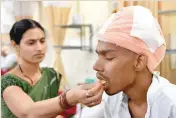  ?? — AFP ?? Santlal Pal, 31, rests in his bed as his wife Manju, feeds him a slice of apple at the BYL Nair Hospital in Mumbai on Thursday.