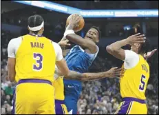  ?? Associated Press ?? Timberwolv­es guard Anthony Edwards (center) works toward the basket as Lakers forwards Anthony Davis (3) and Cam Reddish (5) defend during the first half, Thursday, in Minneapoli­s.