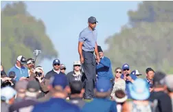  ??  ?? Tiger Woods walks on the 10th green of the Torrey Pines North Course in the first round of the Farmers Insurance in San Diego on Thursday. AP