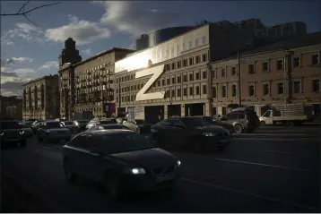  ?? THE ASSOCIATED PRESS ?? Cars in Moscow, Russia, on March 30, 2022, drive past a building decorated with a huge letter “Z,” which has become a symbol of the Russian military operation in Ukraine, along with a hashtag reading, “We don't abandon our own.” The symbols serve as reminders of the conflict that has dragged on for a year.