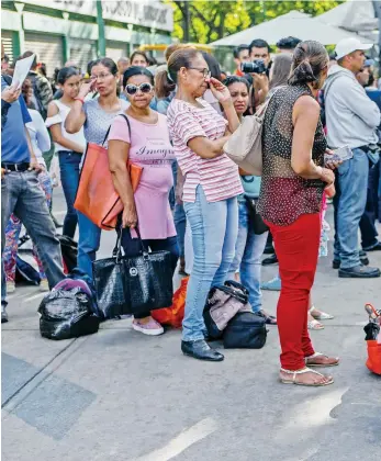  ??  ?? Venezolano­s hacen una fila para intentar abordar unidades de transporte, en Caracas. El colapso del transporte suburbano ha aislado a las localidade­s de Guarenas y Guatire.