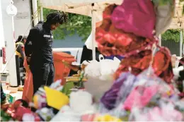  ?? MATT ROURKE/AP ?? The Buffalo Bills’ Josh Thomas visits the scene of the mass shooting at a supermarke­t in Buffalo, N.Y.