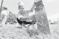  ?? — Gambar Bernama ?? KUNJUNG: Seorang Ahli Persatuan Sejarah mengenal pasti pemilik batu nisan ketika berkunjung ke Tanah Perkuburan Kampung Sungai Emas.