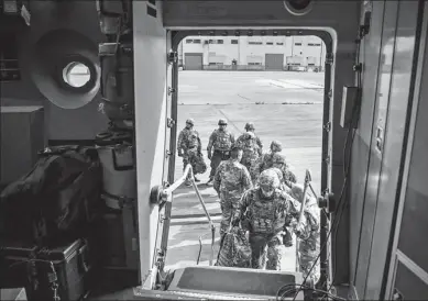  ?? ZOE WOCKENFUSS / AGENCE FRANCE-PRESSE ?? Soldiers board a C-17 Globemaste­r III from the 3rd Airlift Squadron, Dover Air Force Base, Delaware, at Fort Knox, Kentucky in support of Operation Faithful Patriot on Wednesday.