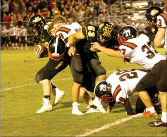  ?? Staff photograph by Mark Humphrey ?? Blackhawk junior Brett Kirby (No. 28) has his helmet pop off while tackling a Prairie Grove running back. The Blackhawks lost their first game of the season Friday to the Tigers, 42-21.
