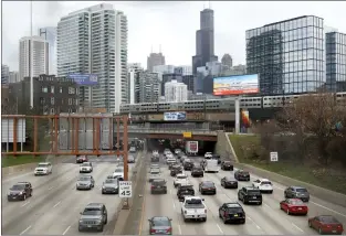  ?? SHAFKAT ANOWAR — THE ASSOCIATED PRESS ?? Interstate 90as a suburban commuter train moves along an elevated track in Chicago. The Biden administra­tion is steering $5billion in federal aid to cities and localities to slow down cars, carve out bike paths and wider sidewalks, and nudge commuters to public transit.