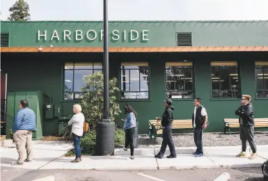  ?? Photos by Michael Short / Special to The Chronicle ?? Customers stand apart for social distancing Tuesday outside of Harborside dispensary in Oakland.