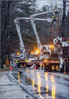  ?? ANDREE KEHN/SUN JOURNAL VIA AP ?? Utility crews work on the lines in Auburn on Friday, Dec. 25 in Auburn, Maine. A storm packing a mix of heavy winds and rain knocked out power to thousands of homes across the Northeast region Christmas morning.