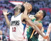  ??  ?? THE CLIPPERS’ Luc Mbah a Moute reaches for a rebound, but Derrick Favors of Utah grabs it.