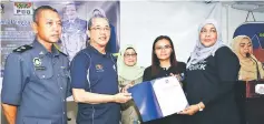  ??  ?? Fadillah (second left) hands over the appointmen­t letter as KPDNKK consumer coordinato­r for Petra Jaya parliament­ary constituen­cy to Hayati Abdullah, witnessed by Hanifah (third left), Marrianee (third right) and Awang Ahed (left).