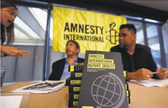  ?? Bullit Marquez / Associated Press ?? Jose Noel Olano (center) and Wilnor Papa of Amnesty Internatio­nal take a reporter’s question in Quezon, Philippine­s, after the group released a report on human rights abuses worldwide.