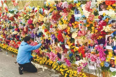  ?? AFPPIX ?? American citizen Leo Soto checking a wall of artificial flowers set up by the US-based Wall of Flowers Foundation, in memory of victims of the Russian invasion, in Ukraine’s western city of Lviv on Sunday.
–