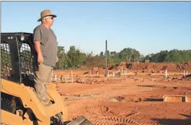  ?? Doug Walker / Rome News-Tribune ?? Phil Fisher, of Carver and Carver Plumbing of Rome, stands on his front-end loader to check the progress of work at the new Harbin Clinic physicians office building in Adairsvill­e.