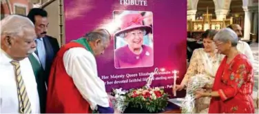  ?? Associated­press ?? A portrait of Queen Elizabeth II is on display as people pay tribute to her during a Sunday service at a church in Lahore.