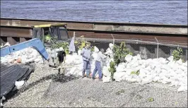  ?? CHARLIE NEIBERGALL / ASSOCIATED PRESS ?? Workers build a sandbag wall on a levee near the Cedar River on Monday in Cedar Rapids, Iowa. Residents are waiting anxiously as the quickly rising Cedar River threatens to inundate their city.