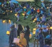  ?? PATRICK CONNOLLY/ORLANDO SENTINEL ?? Festival-goers prepare to launch lanterns during the Orlando Water Lantern Festival at Orlando Watersport­s Complex on Saturday, March 16, 2019.