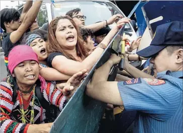  ?? Mark R. Cristino European Pressphoto Agency ?? PROTESTERS CLASH with police in front of the U.S. Embassy in Manila. Hundreds of demonstrat­ors demanded American forces leave their country. A police van knocked over and injured dozens of protesters.