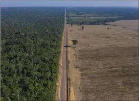  ?? LEO CORREA—ASSOCIATED PRESS ?? In this Nov. 25, 2019photo, highway BR-163stretch­es between the Tapajos National Forest, left, and a soy field in Belterra, Para state, Brazil. Carved through jungle during Brazil’s military dictatorsh­ip in the 1970s, this highway and BR-230, known as the TransAmazo­n, were built to bend nature to man’s will in the vast hinterland. Four decades later, there’s developmen­t taking shape, but also worsening deforestat­ion.