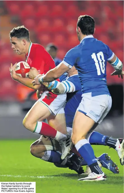  ??  ?? Kieran Hardy bursts through the Italian tacklers to score Wales’ opening try of the game PICTURES: Huw Evans Agency