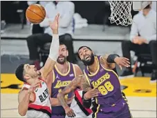  ?? Mark J. Terrill Associated Press ?? TRAIL BLAZERS center Enes Kanter, left, and Lakers forward Markieff Morris (88) battle for a rebound during the first half.