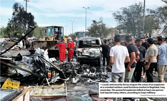  ?? Khalid Mohammed/Associated Press ?? Locals and security forces inspect the scene of an explosion at a crowded outdoor used furniture market in Baghdad, Iraq, yesterday. The powerful explosion killed at least one person and injured many others, according to Iraq’s military