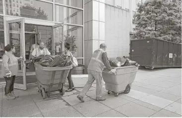  ?? Yi-Chin Lee / Houston Chronicle ?? Contractor­s Yasmin Hernandez Rodas, from left, Jermaine Green, front, Brent Brooks, back, and Andro E. Ochoa Leyva throw out bags of sheetrock and carpet from the Harris County Juvenile District Court building.