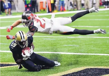  ?? BILL FEIG/JOURNAL ?? Saints wide receiver Ted Ginn (19) pulls in a touchdown pass against Tampa Bay safety Chris Conte in the second half of Sunday’s game. New Orleans has won six straight games.