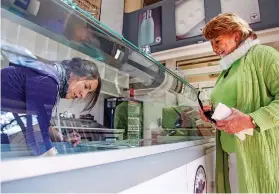  ??  ?? Eileen Loy, left, of La Lecheria prepares a sample of rosemary orange for Lisa Abeyta.