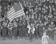  ?? Michael Sohn / AP ?? Erin Hamlin carries the flag of the United States during the opening ceremony of the 2018 Winter Olympics.