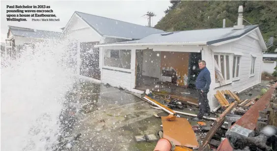  ?? Photo / Mark Mitchell ?? Paul Batchelor in 2013 as pounding waves encroach upon a house at Eastbourne, Wellington.