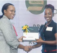  ??  ?? Kasan Troupe (left), Ministry of Education’s director for Region One, presents Lavern Baker, student at the College of Agricultur­e, Science and Education, with an award during the Seprod Foundation’s scholarshi­p awards luncheon.