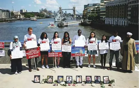  ?? AFP ?? Members of various faiths pose with placards and photograph­s of the people killed in the London Bridge terror attack, on London Bridge, yesterday, prior to a commemorat­ion service on the first anniversar­y of the attack.