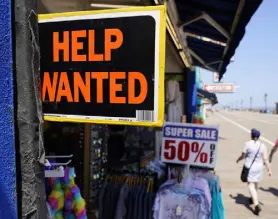  ?? Matt Slocum, The Associated Press ?? People walk past a help-wanted sign in front of a souvenir shop along the boardwalk Thursday in Ocean City, N.J.