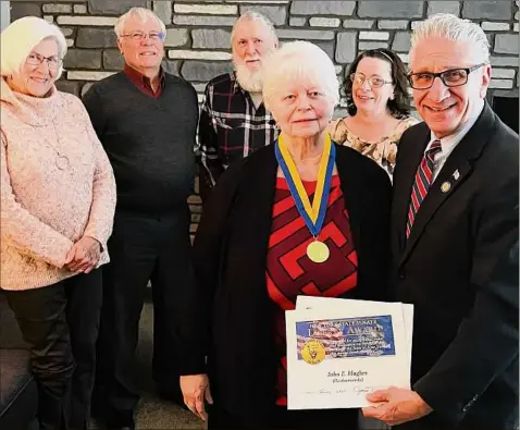  ?? Provided by the office of state Senator Jim Tedisco ?? State Sen. Jim Tedisco presents a New York State Liberty Medal and citation posthumous­ly to the late John E. Hughes of Hadley, an Army veteran of the Vietnam War. The medal is the state’s highest award for military services and valor. Accepting the honor on Hughes’ behalf is his widow, Judy Hughes, as family members look on.