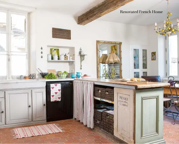  ??  ?? Above: A rustic mix of units with cupboard doors and open shelves with curtains, gives a sense of classic French country kitchen style. When they’re not enjoying the Sancerre weather in the garden, Kath and Stephen spend most of their time in the comfortabl­e kitchen