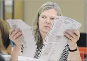  ?? Rich Pedroncell­i Associated Press ?? ALLISON BENTON, a Sacramento County Registrar of Voters worker, scans a mail-in ballot last year.