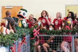  ?? Robin Jerstad / Contributo­r ?? Members of the Oklahoma band get a picture taken with the Oregon Ducks mascot during Wednesday’s volunteer event at the San Antonio Food Bank.