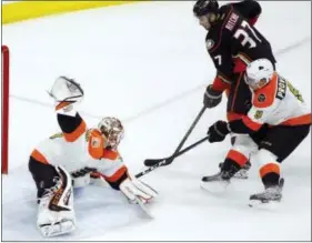  ?? TOM MIHALEK — THE ASSOCIATED PRESS ?? Flyers goalie Steve Mason, left, defends as the Ducks’ Nick Ritchie, center and Flyers’ Ivan Provorov battle for control during the second period Thursday in Philadelph­ia. Anaheim won 3-2.