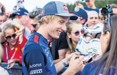  ?? PHOTO: GETTY IMAGES ?? Good signing . . . New Zealand Toro Rosso driver Brendon Hartley signs autographs at Circuit de SpaFrancor­champs yesterday before the Belgian Grand Prix on Monday.