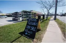  ?? JULIE JOCSAK TORSTAR ?? A pop-up flower shop by Pioneer Flower Farms that works on the honour system is set up at strip mall in St. Catharines.