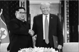  ?? ASSOCIATED PRESS ?? NORTH KOREA LEADER KIM JONG UN AND U.S. PRESIDENT DONALD TRUMP shake hands after a document signing at the Capella resort on Sentosa Island on Tuesday in Singapore.