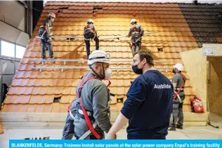  ?? ?? BLANKENFEL­DE, Germany: Trainees install solar panels at the solar power company Enpal’s training facility in Blankenfel­de-Mahlow, south of Berlin.—AFP