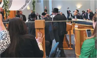  ??  ?? 出席婚禮的男賓，一身黑衣黑帽。