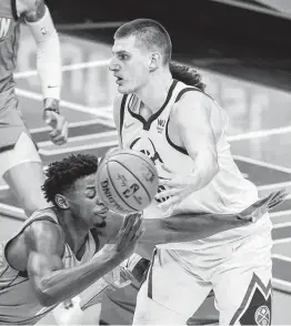  ?? Mark Mulligan / Staff photograph­er ?? Nuggets center Nikola Jokic, right, passes in traffic on Friday. The MVP candidate finished with seven assists, helping lead the Nuggets to a blowout win.