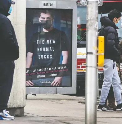  ?? PETER J. THOMPSON / NATIONAL POST ?? Pedestrian­s wear masks near a bus shelter in Toronto on Monday. Ontario Premier Doug Ford says residents
can expect an announceme­nt Tuesday on new measures to stifle the COVID-19 throughout the province.