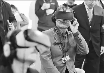  ??  ?? South Korean President Moon Jae-In (centre) wears a virtual reality (VR) headset during the Busan Internatio­nal Film Festival. — AFP photo