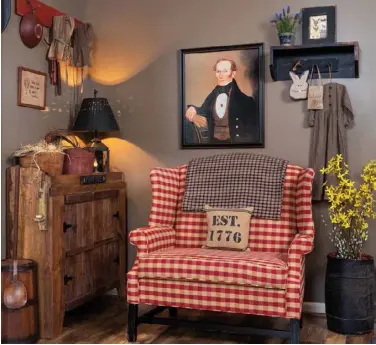  ??  ?? Below: An oversize settee upholstere­d in a red-checked pattern beneath a framed prim portrait of a regallooki­ng gentleman brightens a corner in the living room. Linda stores bowls and linens in the old dry sink. A barrel brimming with forsythia and pussy willow branches introduces the texture and color of spring. 33