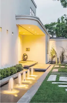  ??  ?? Above: The owner emphasized the pure and simple geometric forms of his classic art moderne style house with a water feature at the entrance and engineered driveway, with paving stones set into the lawn in a herringbon­e pattern.
