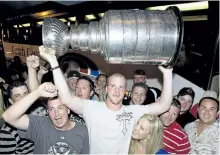  ?? CLIFFORD SKARSTEDT/EXAMINER FILES ?? Chicago Blackhawks and Stanley Cup champion Bryan Bickell hoists the Stanley Cup as family and friends and the coveted cup make an appearance at the Trasheteri­a at Simcoe and Water streets in 2010.